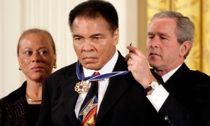 U.S. President George W. Bush awards boxing legend Muhammad Ali (C) with the Presidential Medal of Freedom, as Ali's wife Lonnie watches, during a ceremony in the East Room of the White House in Washington in this November 9, 2005 Photo By Benjamin Rogers, Jr Pointed Magazine Staff